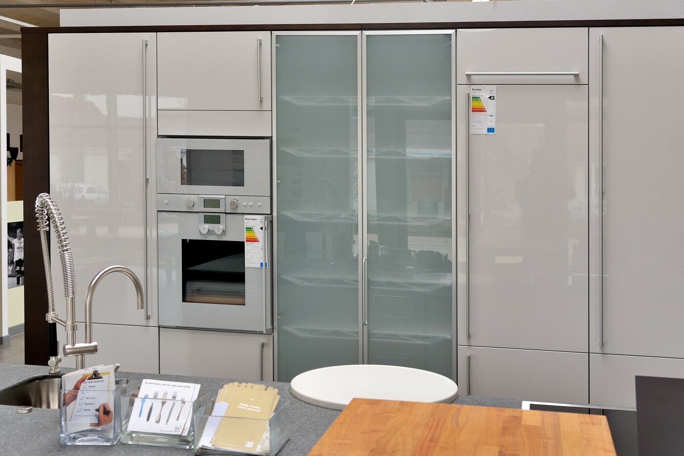 Einbauküche mit sanft-grauen Echtglasfronten, mit denen auch Backofen und Mikrowelle verkleidet sind. Einbauküche mit sanft-grauen Echtglasfronten, mit denen auch Backofen und Mikrowelle verkleidet sind.