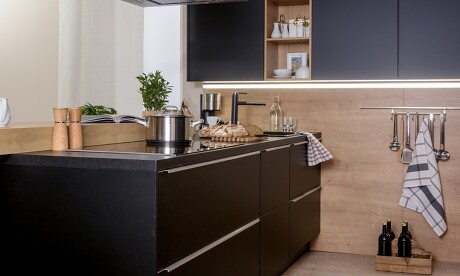 Küche in Schwarz, kombiniert mit Naturholz und Küchenunterschrank-Beleuchtung Küche in Schwarz, kombiniert mit Naturholz und Küchenunterschrank-Beleuchtung